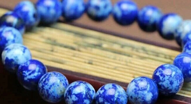 Blue bead bracelet with extensive white mottled patterning