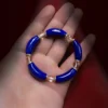 Natural lapis lazuli and clear quartz curved bead bracelet held in a hand