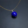 Natural lapis lazuli round pendant with gold-tone chain and small terminal detail