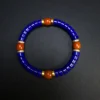 Close top view of blue lapis discs and orange-red Nanhong beads
