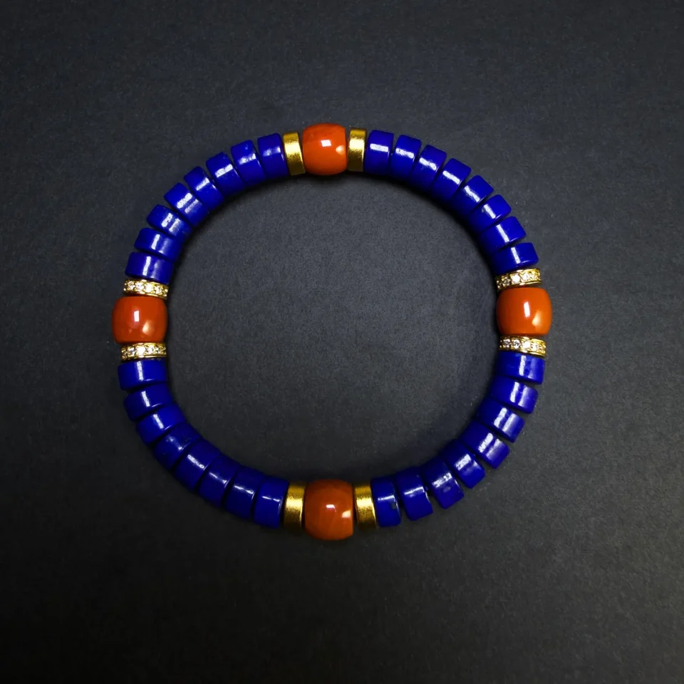 Close top view of blue lapis discs and orange-red Nanhong beads