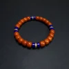 Close full view of orange-red Nanhong beads with blue lapis spacers
