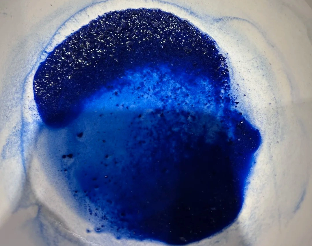 Deep blue powdered lapis lazuli pigment on a pale surface