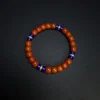 Angled orange-red heishi bracelet with blue lapis and cubic zirconia spacers