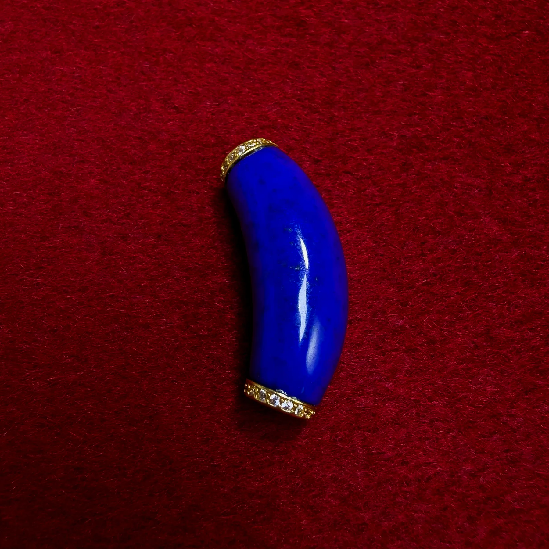 Polished curved lapis lazuli component with gold-plated cubic zirconia spacer details