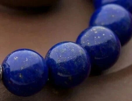 Close-up of polished blue lapis beads with fine golden flecks