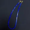 Long view of rectangular lapis lazuli beads and gold clasp on black