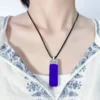 Rectangular lapis lazuli pendant worn on an adjustable black cord