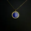 Back view of round blue lapis lazuli pendant on gold-plated chain