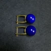Side view of round lapis lazuli beads on U shaped gold-tone earrings