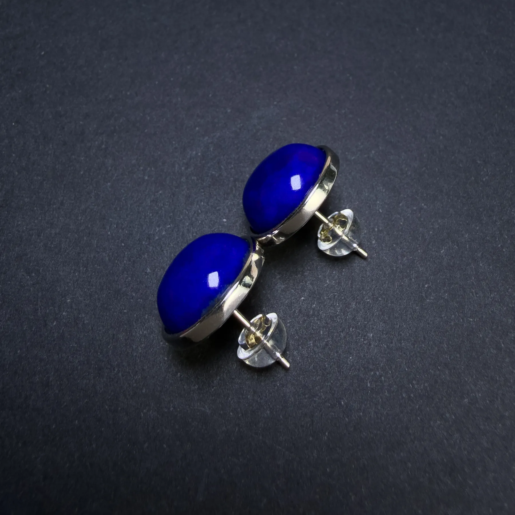Side detail of lapis lazuli cabochon studs with silver posts and clear backs