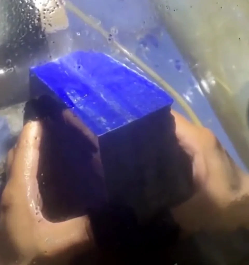 Large Afghan lapis lazuli block being cut with a lapidary saw
