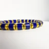 Low-angle detail of blue lapis beads separated by gold-toned components
