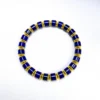 Complete blue and gold lapis lazuli bracelet on a white background