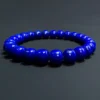 Side view of polished blue lapis barrel beads on elastic cord