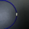 Two freshwater pearls centered between small royal-blue lapis beads