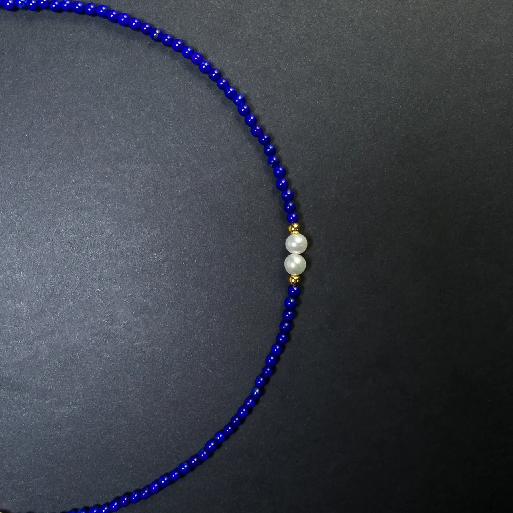 Two freshwater pearls centered between small royal-blue lapis beads