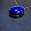 Close detail of gold-toned prongs around oval blue lapis lazuli