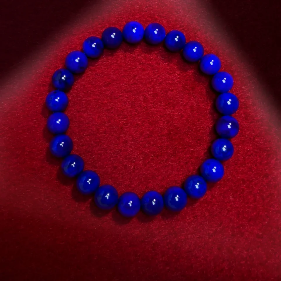 Top view of the lapis lazuli bracelet with reflections across the round blue beads