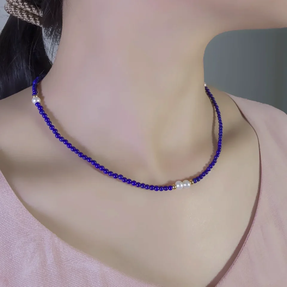 Dainty blue lapis lazuli and pearl necklace worn at the collarbone
