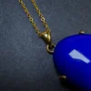 Gold-toned bail and chain attached to oval lapis lazuli pendant