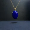 Oval lapis lazuli pendant suspended from a gold-toned chain