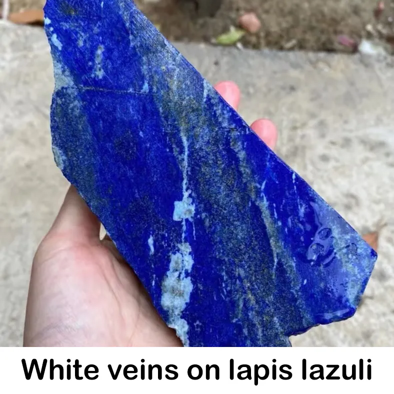 White calcite veins running through blue lapis lazuli rough
