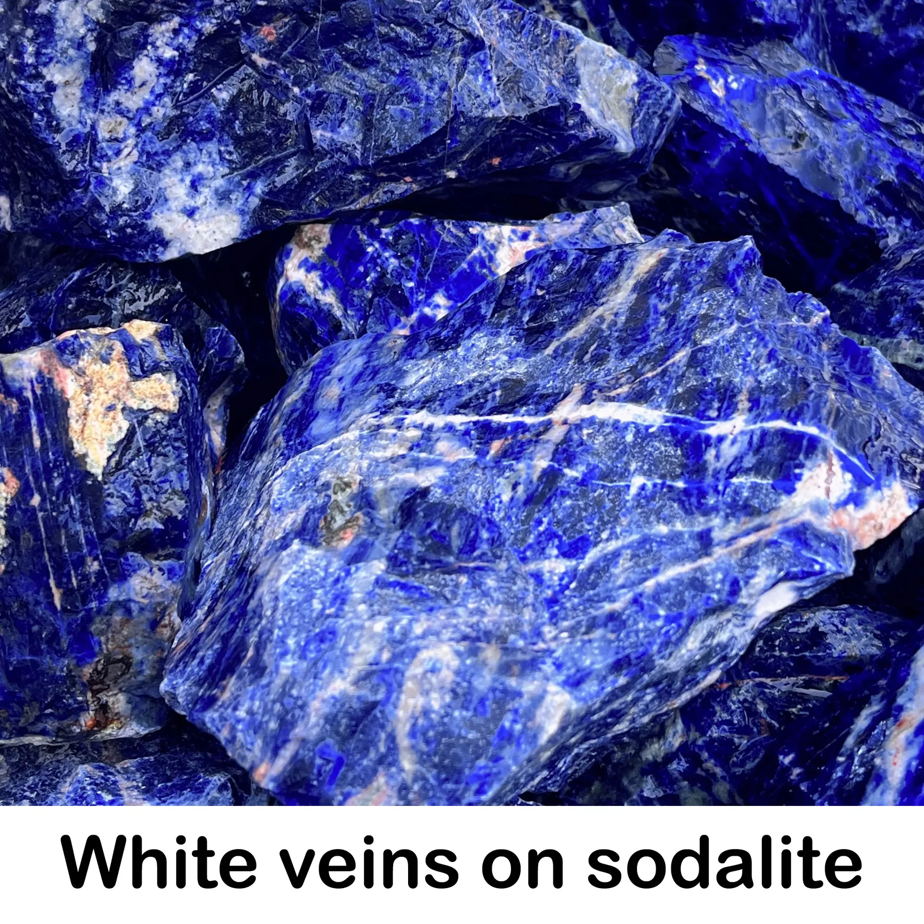 White veins running through blue sodalite rough