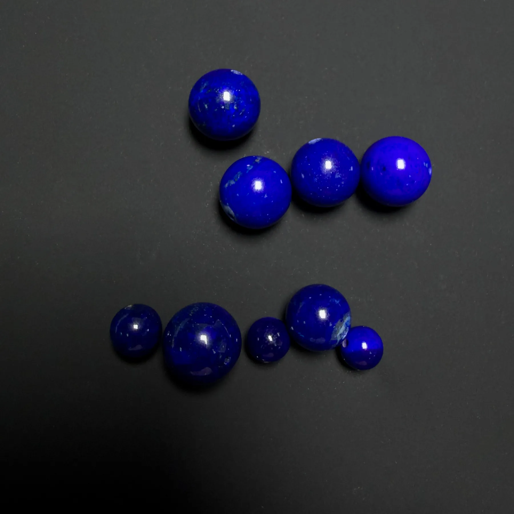 Very dark natural lapis and brighter blue lapis on a dark background