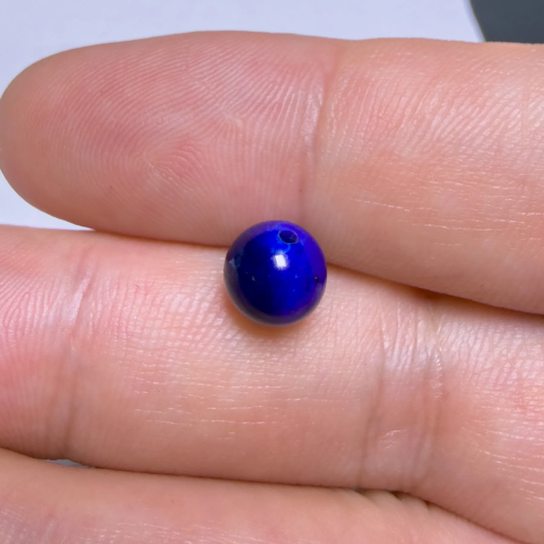 Macro close-up of a lapis bead with one deep-blue side and one near-black side