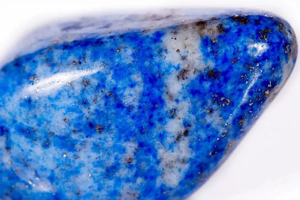 Close-up of Chilean lapis lazuli with blue areas, pale mineral patches and small metallic flecks