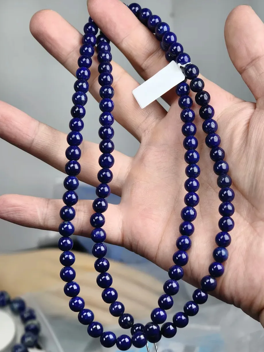 Dark blue lapis bead strands with some areas appearing almost black in the photograph