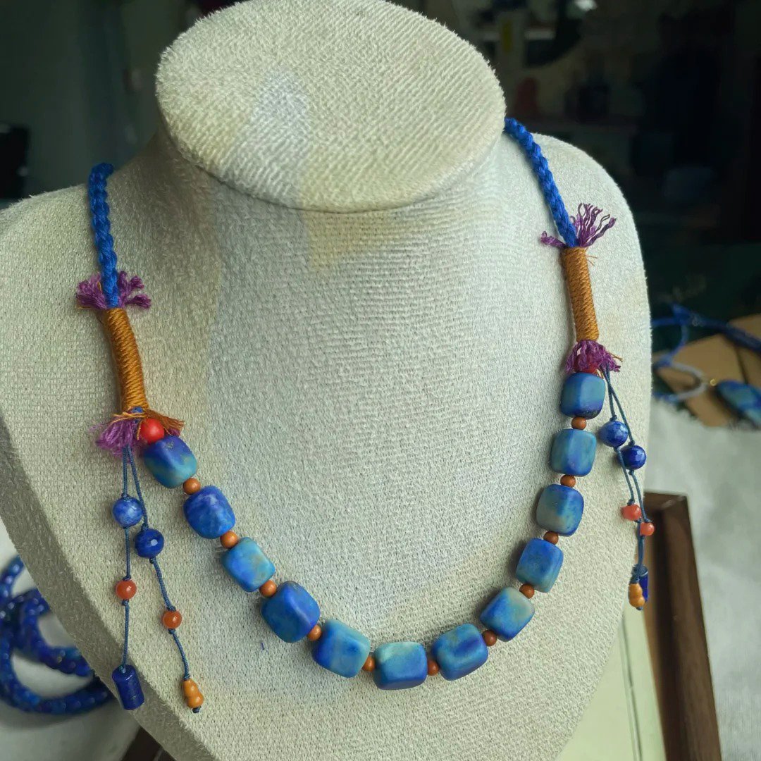 Denim lapis lazuli necklace with blue-gray rectangular beads on a display bust