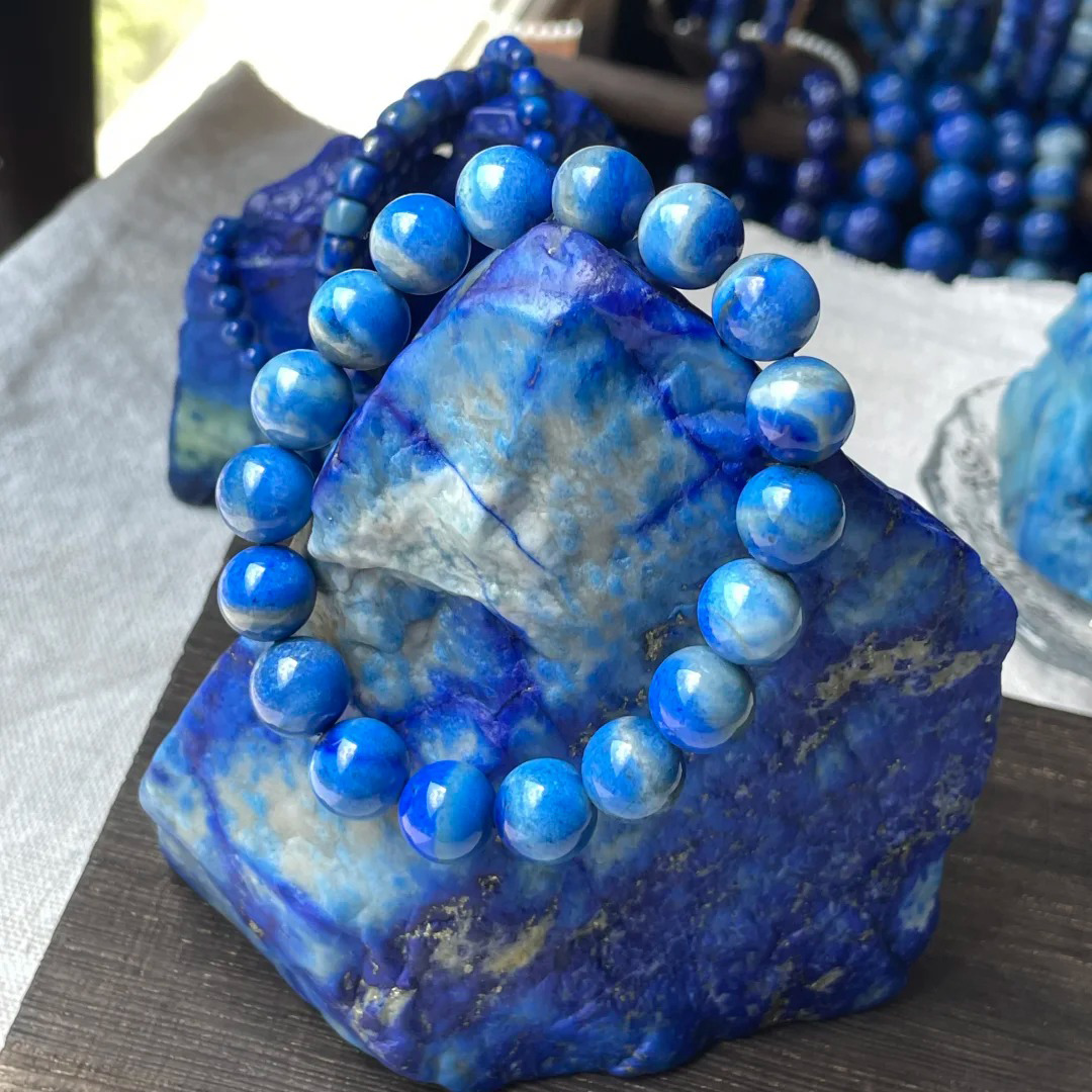 Denim lapis lazuli bead bracelet displayed on blue-and-pale lapis material