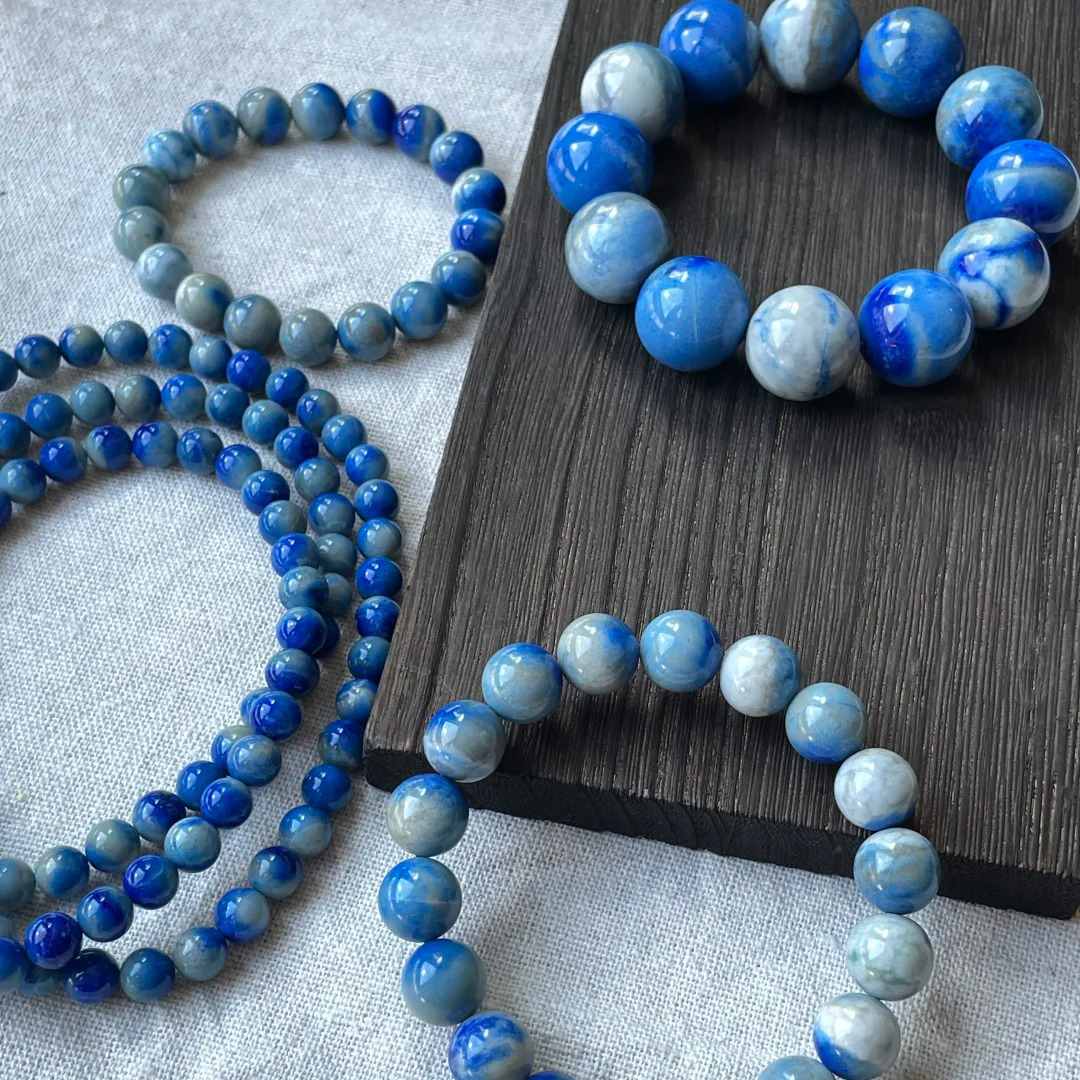Assortment of denim lapis lazuli bracelets and bead strands showing blue-gray patterns