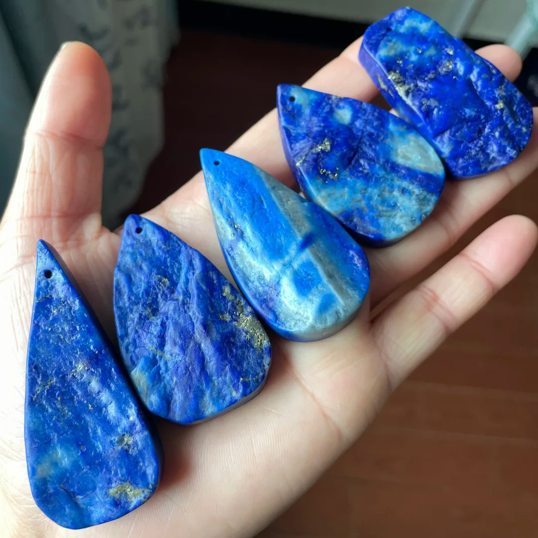 Five denim lapis lazuli teardrop pendants with varied blue and pale patterns