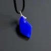 Close angled view of the lapis pendant showing its sloped polished face and side facet