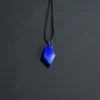 Wider view of the royal-blue freeform lapis pendant suspended from a long black cord