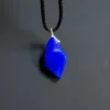 Oblique view of the blue lapis pendant with silver fitting and a pale line near the edge