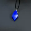 Upright front view of a faceted blue lapis pendant showing its uneven geometric outline