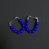 Second angled view of the two royal-blue lapis beaded hoop earrings