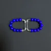 Two lapis beaded earrings laid sideways to show the silver posts and clasps