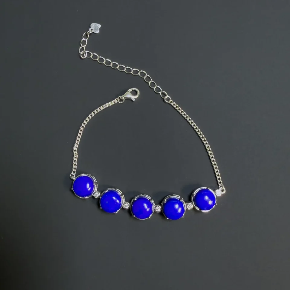 Lapis lazuli bracelet arranged with its lobster clasp open beside the extended silver chain