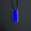 Straight-on front view of the long blue lapis pendant hanging from a black cord